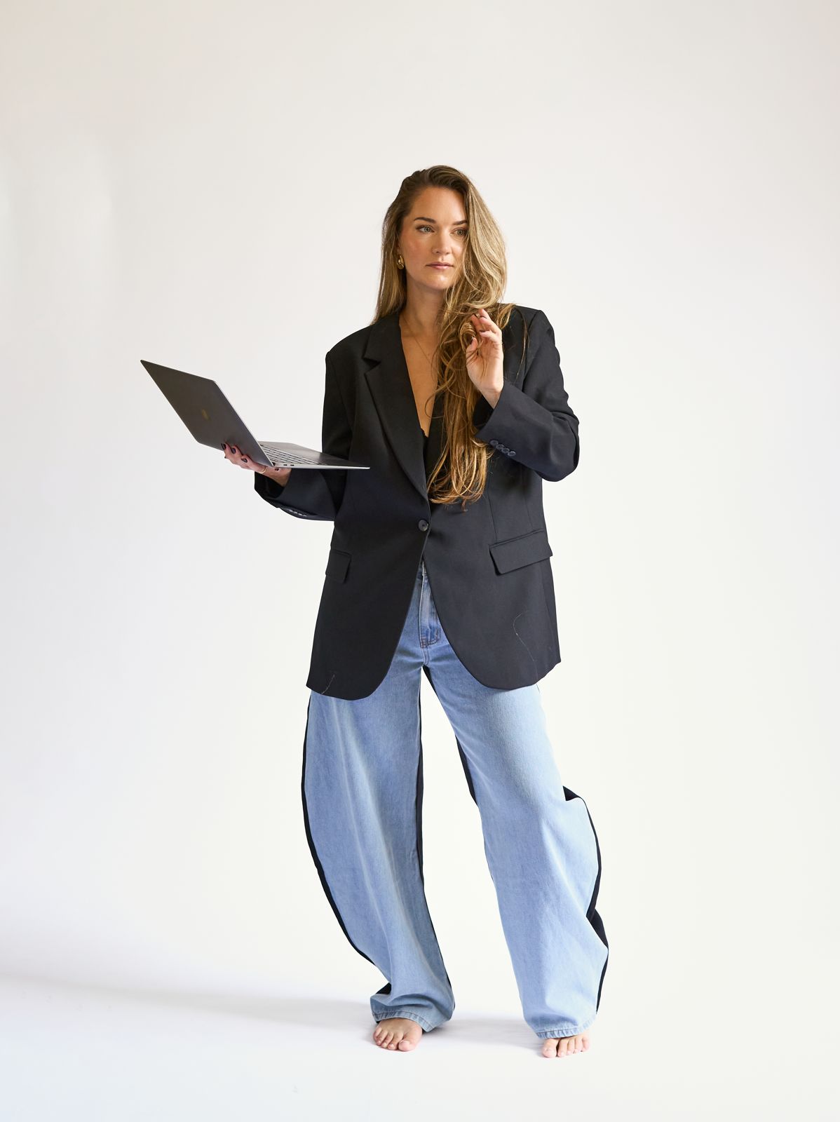 Lianne van Alphen op blote voeten met laptop in haar hand