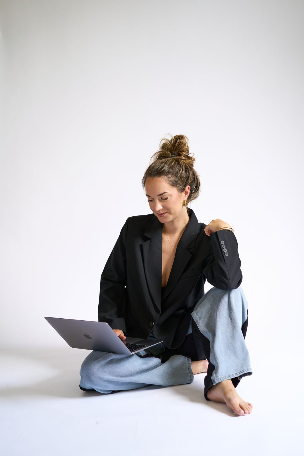 Lianne zittend op de vloer, werkend op haar laptop